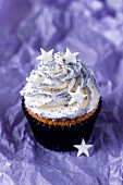 A cupcake topped with vanilla cream and decorated with stars