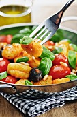 Gnocchi with tomatoes, olives, pine nuts and basil