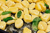 Gnocchi with butter and sage in a pan (close-up)