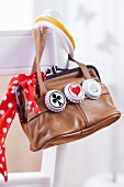 Retro handbag decorated with three bottle tops painted with different motifs