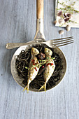 Black spaghetti with sardines in a pan
