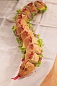 A snake baguette decorated with ketchup for a party