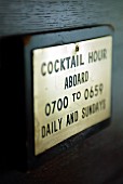 A sign detailing the opening hours of a cocktail bar