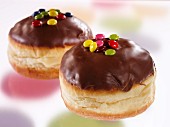 Chocolate glazed doughnuts decorated with coloured chocolate beans