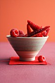 A bowl of raspberries and strawberries