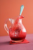 Raspberry sauce in a glass jug