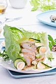 Chicken salad with quail's eggs and cucumber in a leaf lettuce