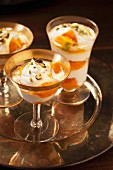 Mango trifle with pistachios in stemmed glasses