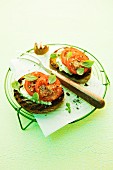 Crostini topped with pesto, cream cheese and tomatoes