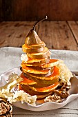 A pear tower with oranges, cheese, walnuts and orange syrup