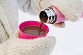 Hhot chocolate being poured into a cup