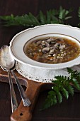Mushroom and barley soup on a wooden board