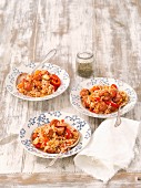 Three portions of rice bake with tomatoes, sausage, pepper, carrots and leek