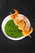 Cream of pea soup with a prawn skewer