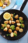 Fried potatoes with coriander in a pan