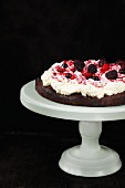 A chocolate cake topped with cream and blackberries