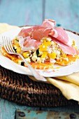 Grain salad with oranges, peppers, courgettes and Parma ham