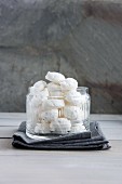 A jar of meringues with hazelnuts and icing sugar