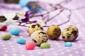 Quail's eggs and sugar eggs on a spotted cloth