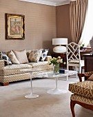 Classic interior in shades of beige with graphic pattern on upholstered furniture and Italian, fifties-style tulip tables