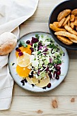 A mixed leaf salad with citrus fruits, cranberries and a side of chips