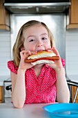 Kleines Mädchen isst ein Hot Dog