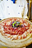 A chef serving a ham platter
