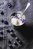 Vanilla ice cream with blueberries and sugared violets in a small metal cup
