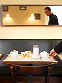 A table laid for breakfast with cappuccino and croissants in a bistro cafe