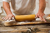 A confectioner rolling out biscuit dough