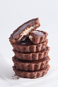 A stack of chocolate tartlets with a coconut filling