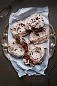 Chocolate meringues on a metal plate with baking paper
