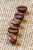 Five coffee beans on a piece of jute