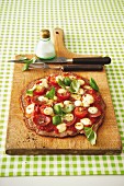 Escalope pizza topped with salami, tomatoes and moozzarella