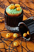 A cupcake decorated with marzipan pumpkins for Halloween