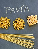 Various different types of pasta on a slate sheet