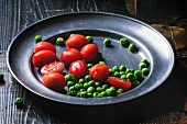 Cherry tomatoes and peas on a metal plate