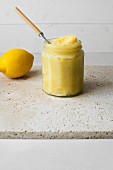 A jar of lemon cream with a spoon