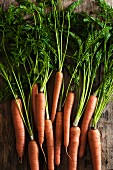 A bunch of carrots on a wooden surface