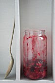 Himbeer-Cranberry-Marmelade im Glas, halb aufgegessen
