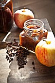 Jars of homemade apple chutney with fresh apples and spices