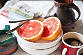 Breakfast with coffee, grapefruit and newspapers