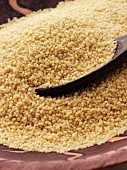 A wooden spoon in a pile of cooked couscous