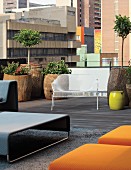 Seating area with designer furnishings and planters made form hollowed-out tree trunks on loft terrace in Johannesburg, South Africa