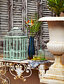Birdcage and vase on wrought iron and marble console
