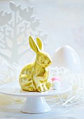 A golden Easter bunny on a cake stand