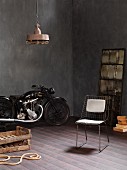 Zimmerecke mit Vintage Motorrad, Metallgitterstuhl und rustikalen Holzkisten