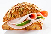 A pumpkin seed roll filled with mushroom mortadella and cucumber