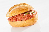 A crusty roll filled with raw minced meat and onions