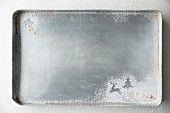 A baking tray with Christmas shapes dusted in icing sugar